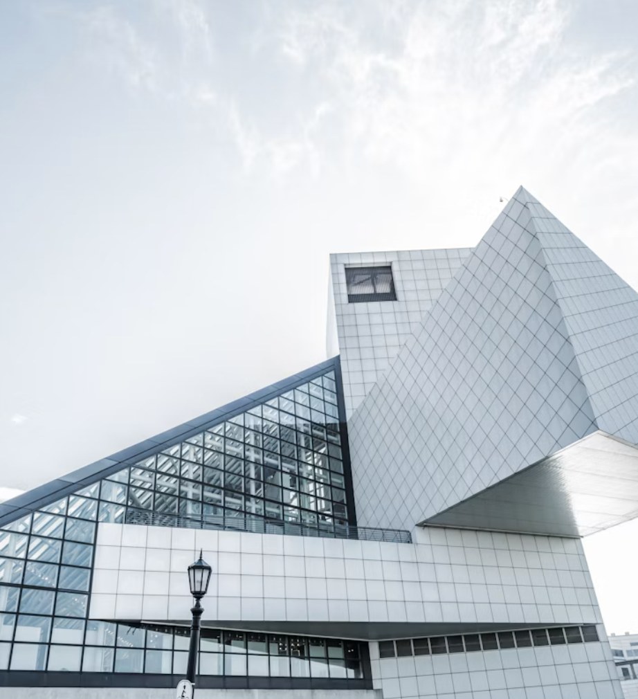 White tiled building with angled glass facets against a pale sky